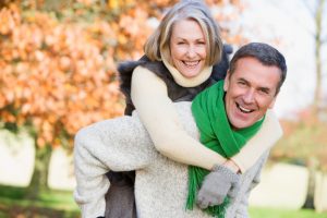 Senior man giving woman piggyback ride